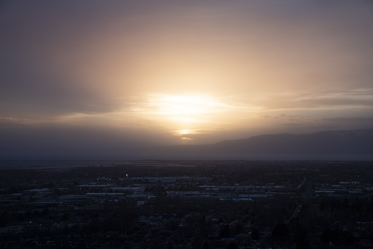 Sunlight glows through an opening in the clouds near sunset